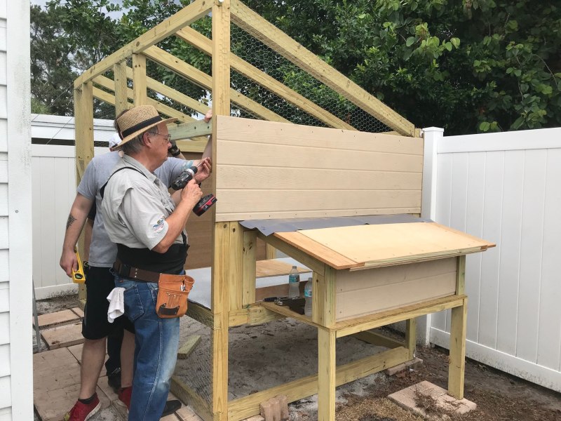 Daniel Hopkins builds a wooden chicken coop with his son, Jonathan.