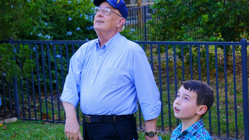 Daniel Hopkins and grandson gaze upwards at the sky together.