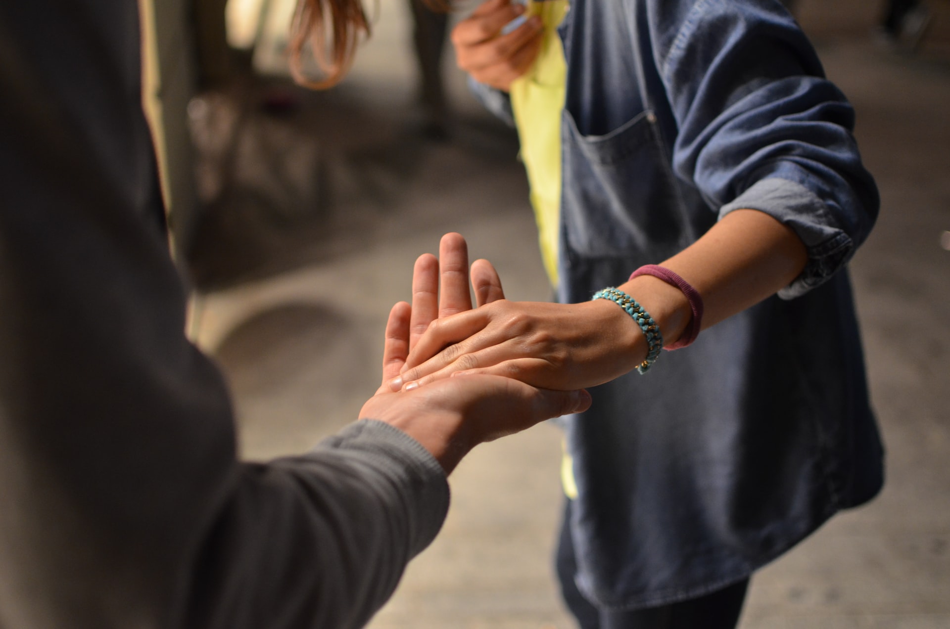 Close up on two people joining hands in fellowship.